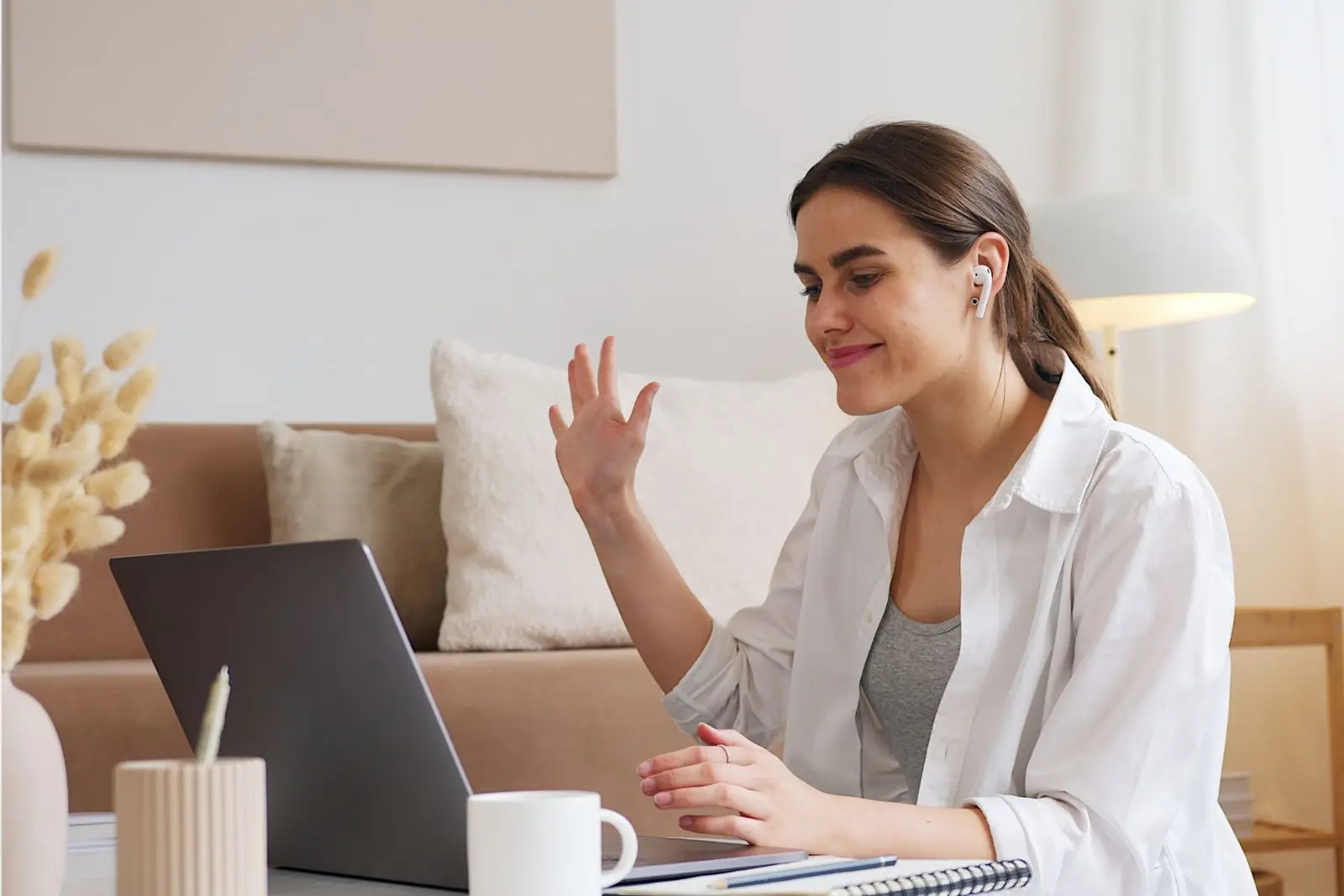 Woman on a video call at home with skincare products beside her
